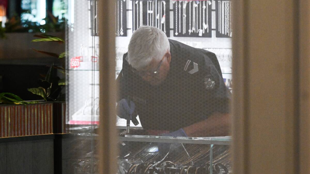 One of the damaged display cases at Prouds in Wangaratta is examined. File photo