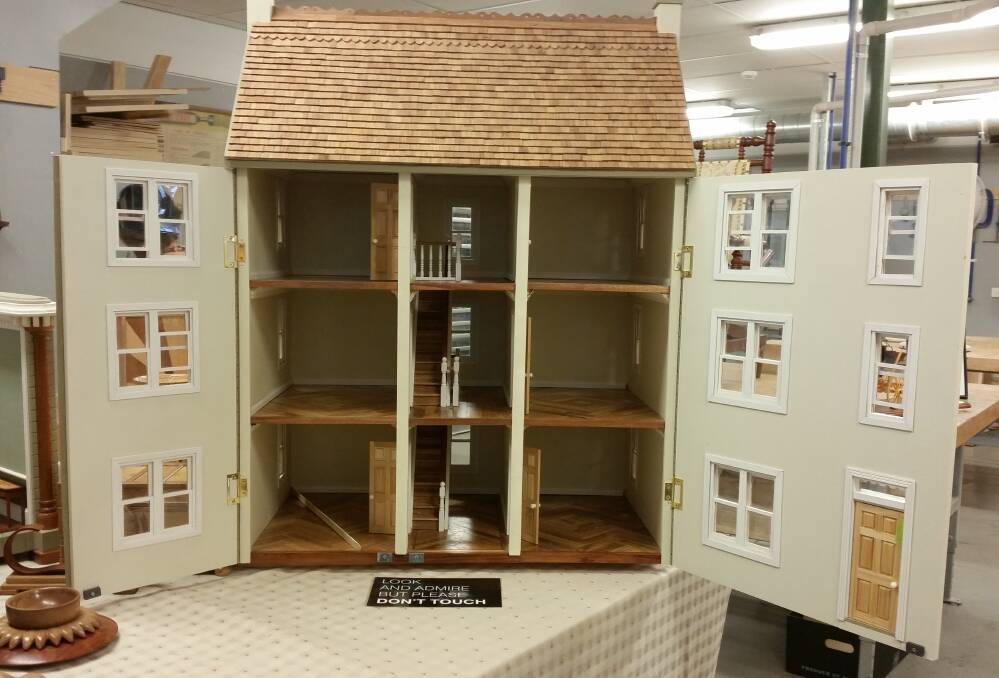 WORK OF ART: Woodworker Ray Hill and the guild's furniture group created this doll's house which will be the first prize at the annual Wood and Craft Show raffle.