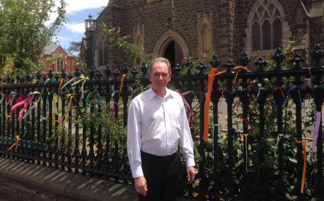Priestly support: Bishop Paul Bird tied a ribbon to the gates of St Patrick's Cathedral in support of clergy abuse survivors. He is the first bishop in Australia to publicly join the Loud Fence movement aiming to end abuse silence. 