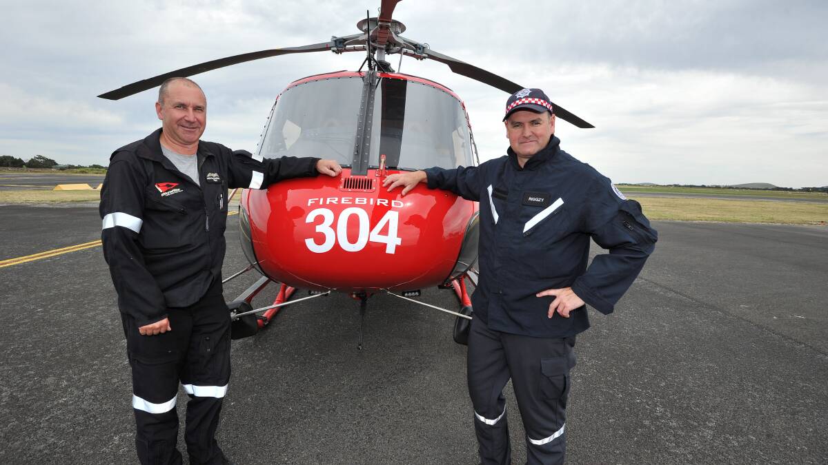 Neville Wright and Wayne Rigg stand in front of fire fighting choppers which arrived at the Ballarat airport. earlier this month.