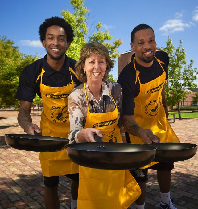 COOK UP: Ballarat Miners players Davon Usher (left) and Marvin King-Davis (right) prepare for the big event with UnitingCare chief Carolyn Barrie. Picture: Luka Kauzlaric