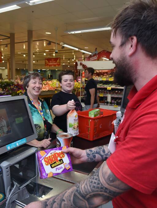 CHECK OUT: Coral and Corey Loader, at the checkout with Coles Wendouree dry goods manager Daniel Tonkin, have welcomed the Quiet Hour initiative. Picture: Kate Healy