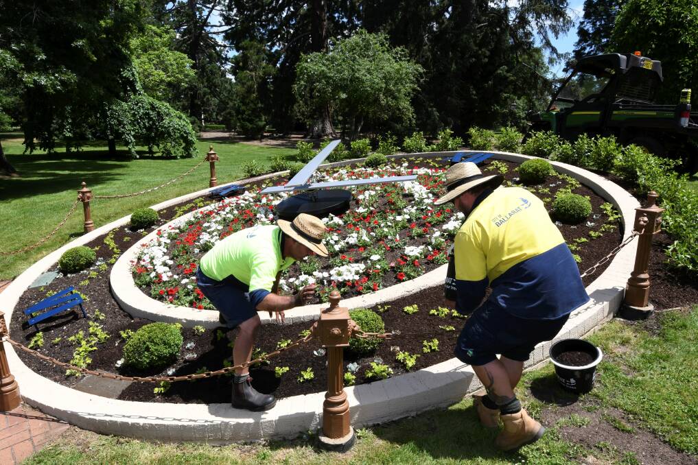 Council workers plant flowers at the floral clock. Picture: Lachlan Bence