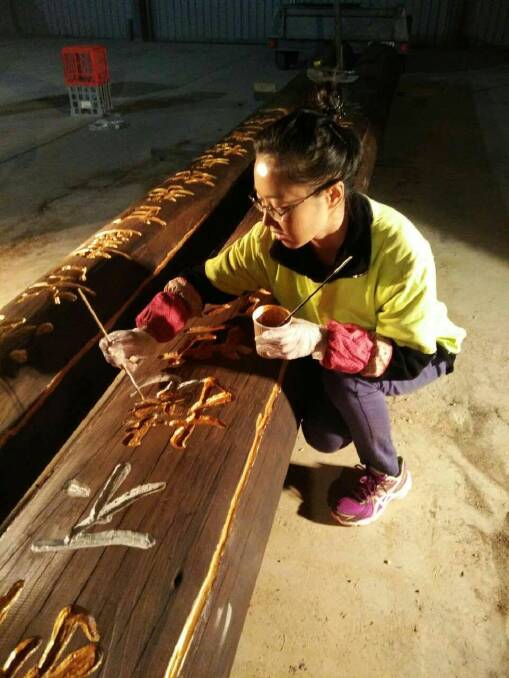 WOOD WORK: An artist works on the Pai Fang welcome gate calligraphy to remember Australia's Chinese migrants who arrived on the Ballarat gold fields in the 1850s.