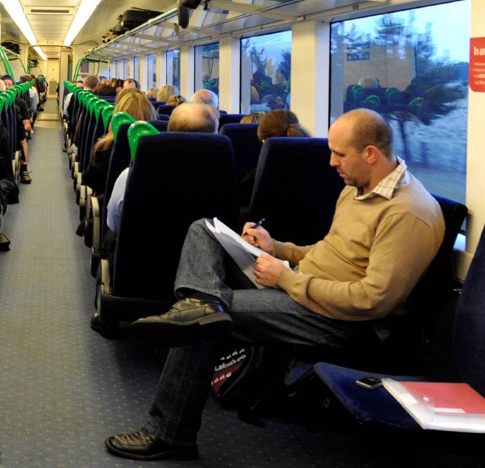 Reliable: A commuter on the Ballarat line sticks to pen and paper in this file photo. The government says mobile blackspots will soon be gone as new towers are announced. PICTURE: Jeremy Bannister