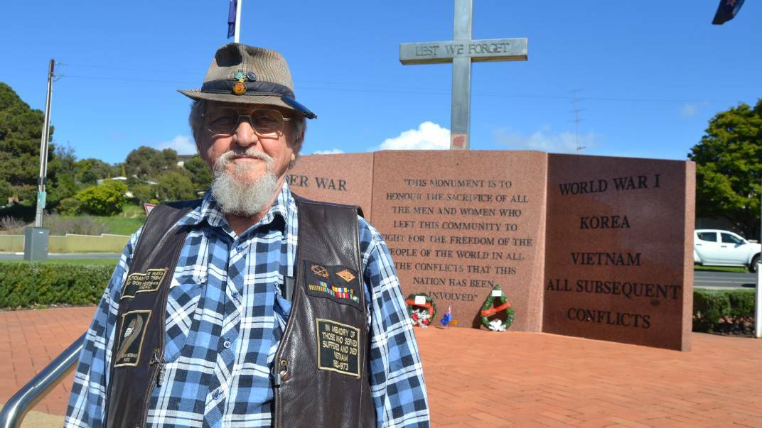 TRIBUTE: Rob Eade stood in front of the Port Lincoln war memorial, with two wreaths and a flag to remember Lt Anthony Austin Casadio.