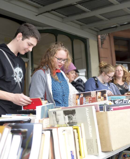Fossicking: Literature-lovers trawl through boxes of bargain books to find what kind of gems Clunes has to offer during the Booktown festival. Picture: Dylan Burns