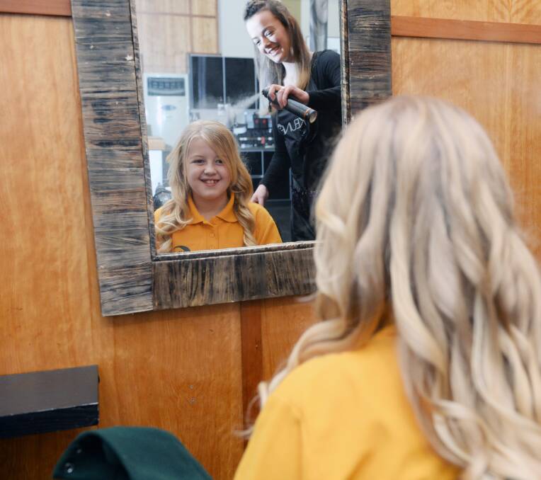 SPRAYED: Lexi, 10, gets the finishing touches from hairdresser Nicole Overall as part of her makeover.