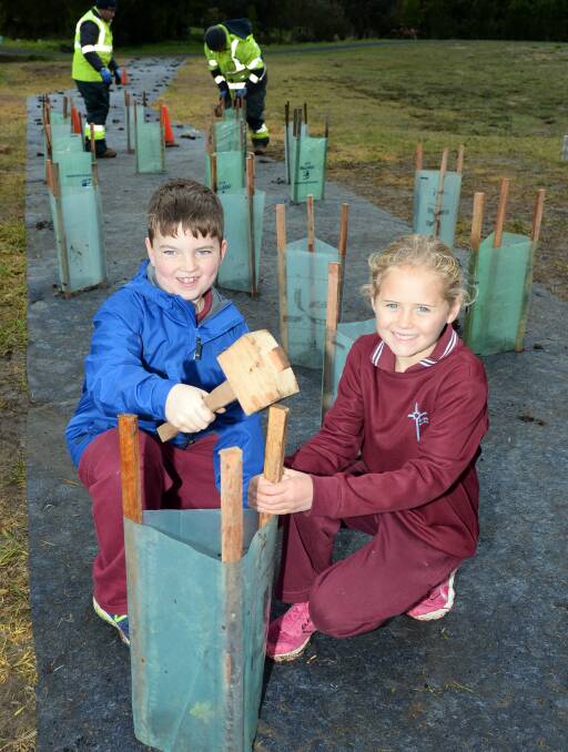 ENVIRONMENTALLY AWARE: St Alipius Parish School pupils Jed, 8, and Jessica, 7, plant trees along the Yarrowee Creek as part of Schools Tree Day. Picture: Kate Healy