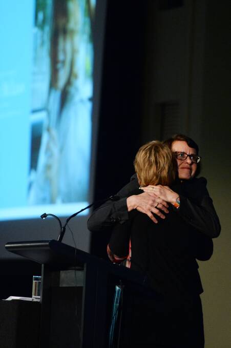 EMOTION: Sally McLean's friends Anne Monagle (back to us) and Mandy Kennedy embrace at her memorial service. Picture: KATE HEALY