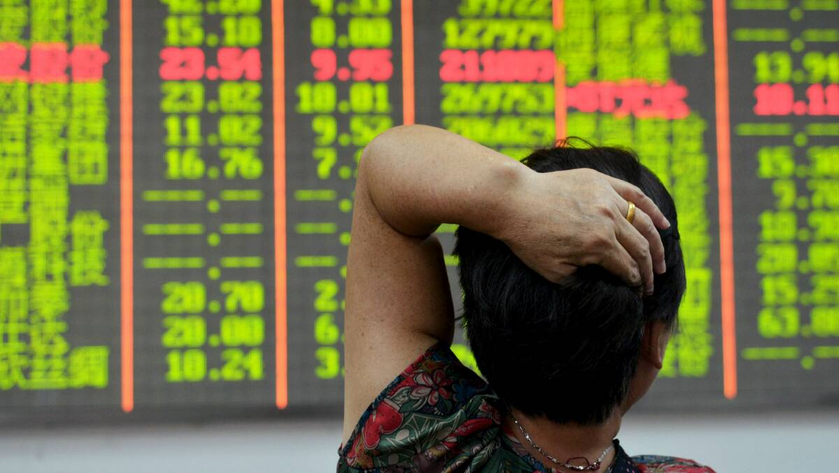 FINANCIAL CRISIS: A Chinese investor looks at the stock market results as the world awaits a “hard landing” of the Chinese economy.
