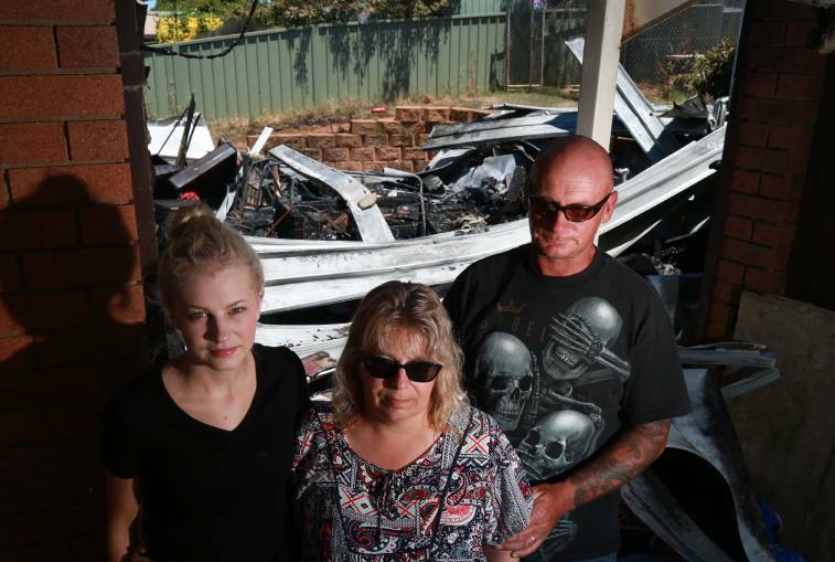 Lindel, Veronica and Matthew Fowler and their fire-ravaged backyard. Photo: PHIL BLATCH
