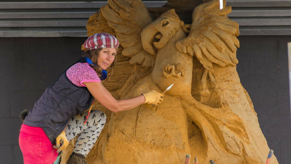 At work: Artist Meg Murray works on her sand sculpture for the 2016 New Year's Eve celebrations near the Burnie Surf Life Saving Club.