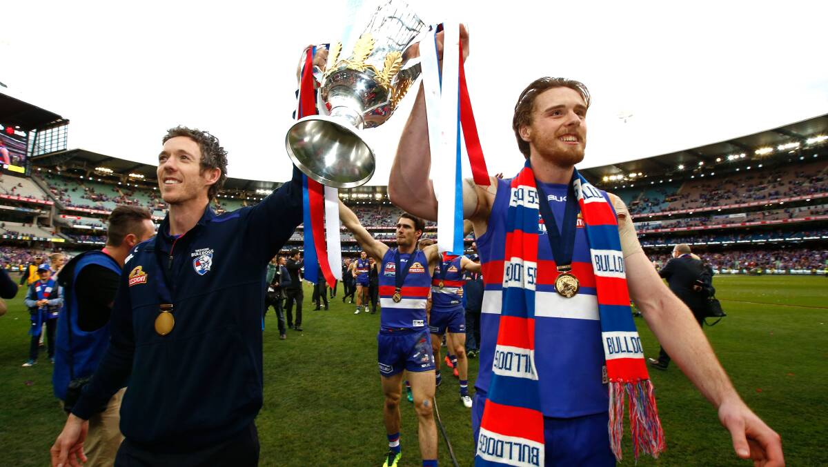 Bob Murphy of the Bulldogs and Jordan Roughead of the Bulldogs carry the premiership cup off the field during the 2016 Toyota AFL Grand Final. Pic: Adam Trafford/AFL Media/Getty Images