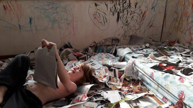 Alex McNeill in his room shredding papers. His parents say they need more support to take care of him at home. Photo: Supplied
