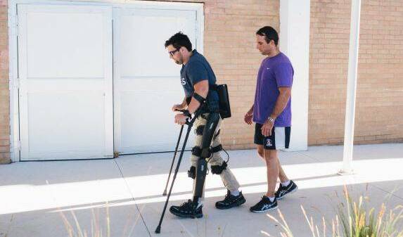 Paraplegic Paul Jenkins learning to walk with bionic legs with exercise physiologist Jim Barrett. Photo: Rohan Thomson