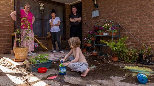 Alex playing outside is watched by mum, Martina, far left, his support worker, and his dad, Rodney. Photo: Daniel Pockett
