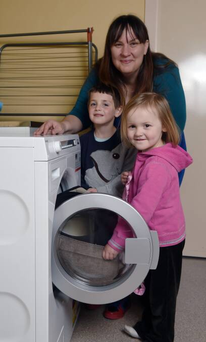 GRATEFUL: Trinsa Lewis, Max Carman, 5 and Erica Lewis, 3, check out the new washing machine, which will wash goods before they are donated. Picture: Kate Healy