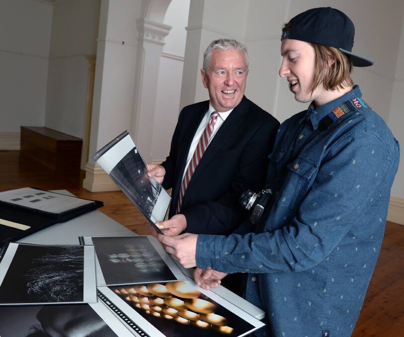 TALENTED: Former Ballarat Clarendon College student Matt Ray, right, shows his photography folio to principal David Shepherd. Picture: Kate Healy