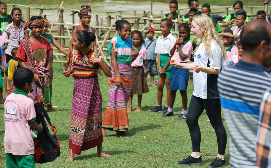HAPPY: Ballarat Grammar year 11 student Abby Gilmore plays with residents from the Mau Nuno village while on a trip to Timor Leste.