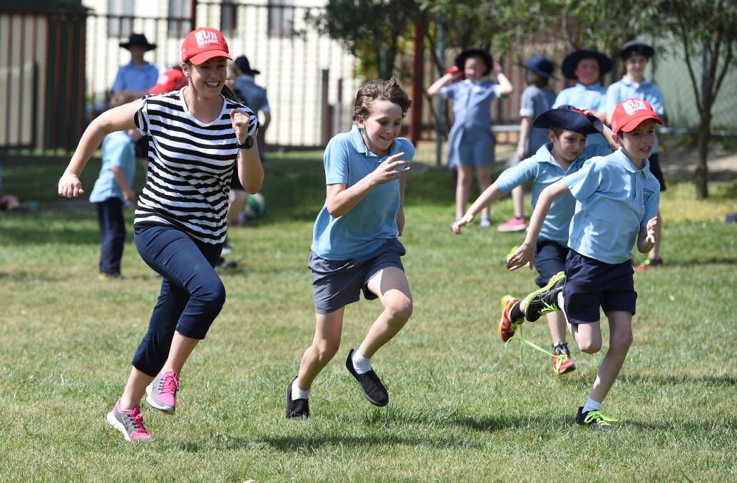 RACE IS ON: Mount Pleasant Primary School teacher Jane Delorenzo races pupils Marcus Borch (grade 6), Johnny Burgess (grade 1), and Ryder Hill (grade 3). Picture: Kate Healy