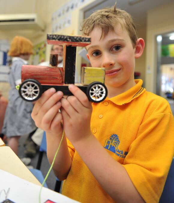 WOOD WORK: Black Hill Primary School prep pupil Tamas, 6, with a toy train he built to raise funds for this year's 3BA Christmas Appeal. Picture: Lachlan Bence