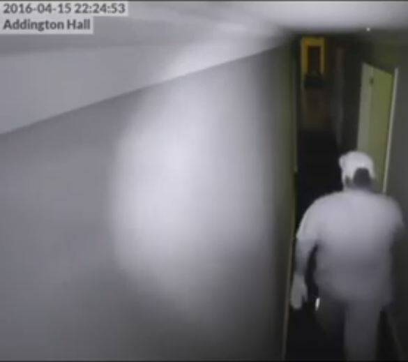 A man is captured walking down the hallway. 