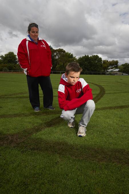 DISAPPOINTED: Ballarat Soccer Club secretary Shae and son Jay Frary, 11, survey the damage done by reckless vandals to the Trekardo Park. Picture: Luka Kauzlaric