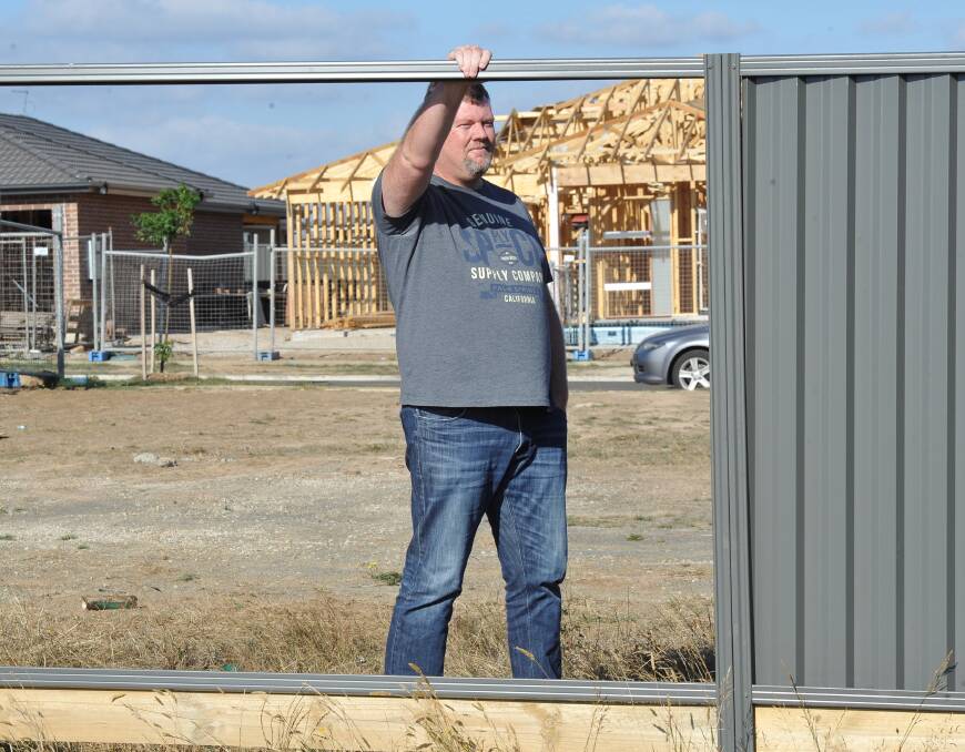 UNIMPRESSED: Gavin Lang checks out what was once his fence. Thieves took 10 metres of paneling. Picture: Lachlan Bence
