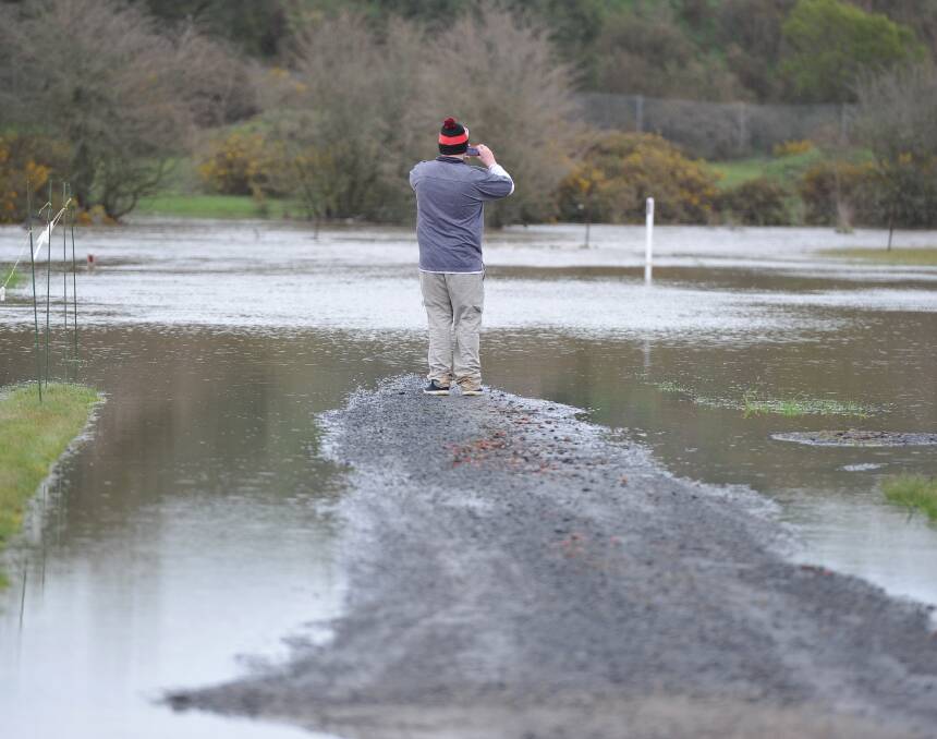 FLOOD PLAINS: Miners Rest resident Nathan Eldridge takes photograph of the flooded  streets near his home. Picture: Lachlan Bence 