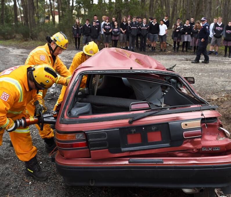 FULL FORCE: Firefighters work to free two trapped people in a simulated car accident as a lead-up to Fatality Free Friday. Picture: Lachlan Bence 