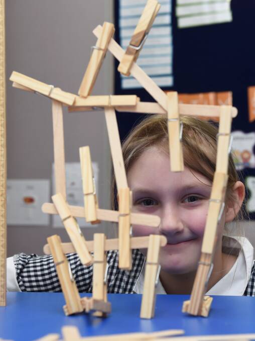 CONSTRUCTION: Grade three pupil, Venus, puts her engineering skills to the test. Picture: Lachlan Bence.
 