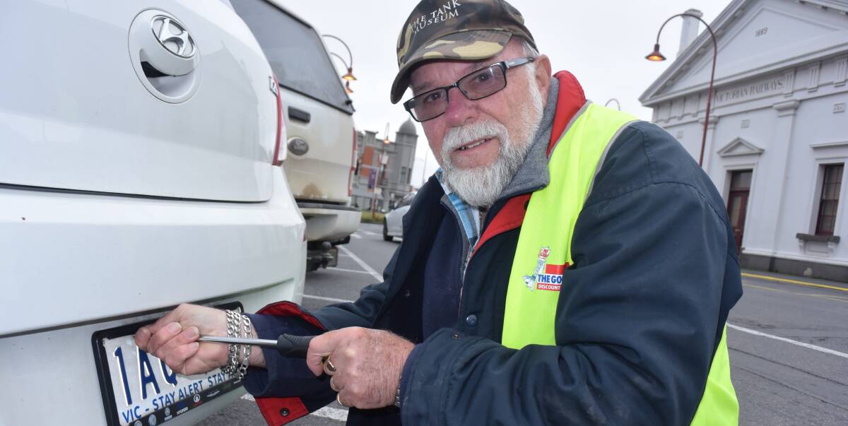 OPERATION SAFE PLATES: Neighbourhood Watch volunteer Wayne Cunningham installs number plates at the Ballarat Railway Station.