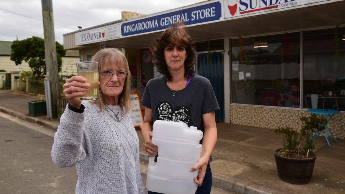 WATER WOES: Kerrie Hales holds water sample and Ringarooma General Store owner Bek Singline with one of her three water containers. Pictures: Paul Scambler