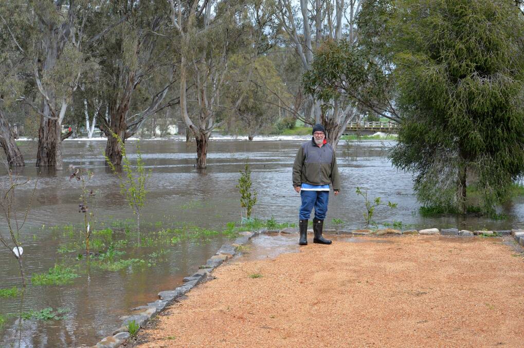 David Anderson watching the flood waters rise toward his business at Barringhup. Picture: DARREN HOWE