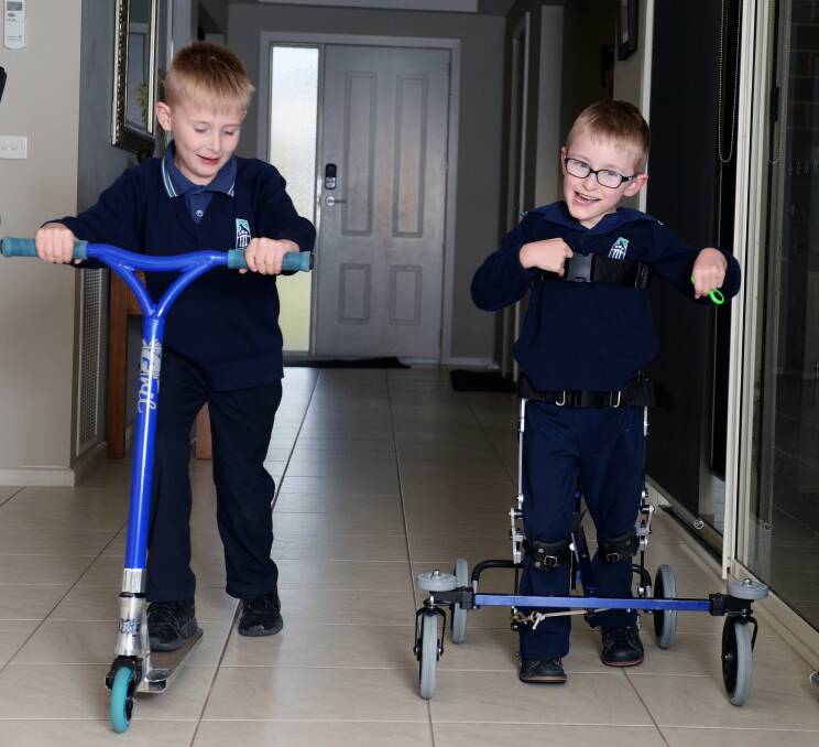 COMPETITIVE: Archie Sims (right) loves a chance to run against his brother Jake in speedy corridor showdowns now he is growing stronger in his specialised, custom-fit walker. Picture: Kate Healy