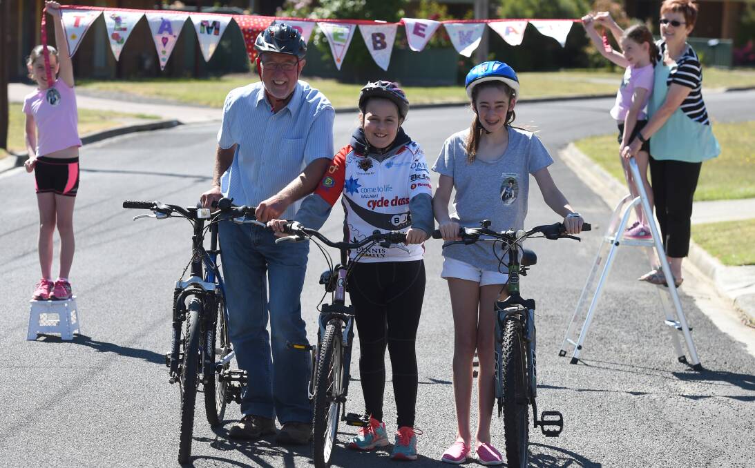 LEGACY: Trish Watt helps granddaughters Keely and Jaida Watt fly the team flag while Barry Watt, neighbour Kate Littlehales and Mikayla Watt get bikes ready to ride for research in honour of Rebekah. Picture Lachlan Bence.