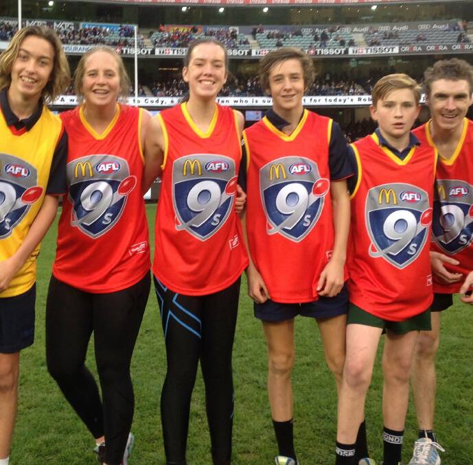 TEAM: Whitten Project participants from Ballarat, including Kathryn Hutchins (second from left) hit the field at half-time in AFL action.