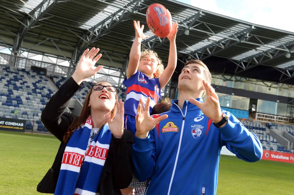 IMPACT: Five-year-old Charlie takes a flying mark above Ballarat councillor Amy Johnson and Western Bulldogs premiership player Josh Dunkley at Eureka Stadium on Friday. Picture: Kate Healy
