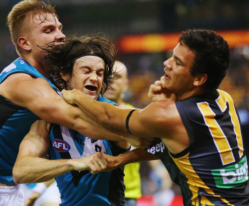 CRUNCH TIME: Well, almost crunch time. Pre-season is flat but young Tiger and Rebels' export Daniel Rioli gets a fiery taste of AFL action from Port Adelaide's Jasper Pittard and Ollie Wines (left) on Thursday. Picture: Getty Images