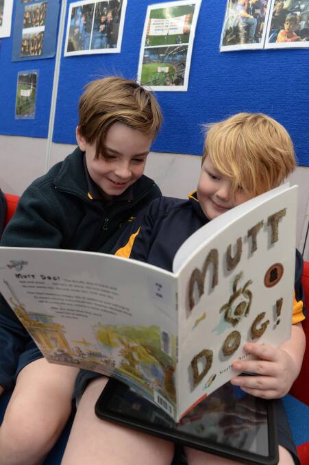 ENTERTAINING: Taj (grade four) and Callan (grade three) are immersed in the tale of the homeless Mutt Dog, which Taj has reviewed for Bulldogs Read. Picture: Kate Healy