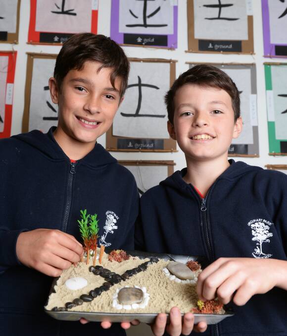 HARMONY: Urquhart Park grade six pupils Jackson and Rory work together to create their peaceful and ordered zen garden on the school's annual Japanese Day this week. Picture: Kate Healy