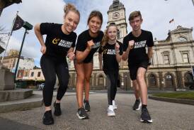 Young runners Ebony Howes, Charlotte Streat, Amali Torney and Cody Torney get warmed up for a big Ballarat Marathon running festival. Picture by Lachlan Bence