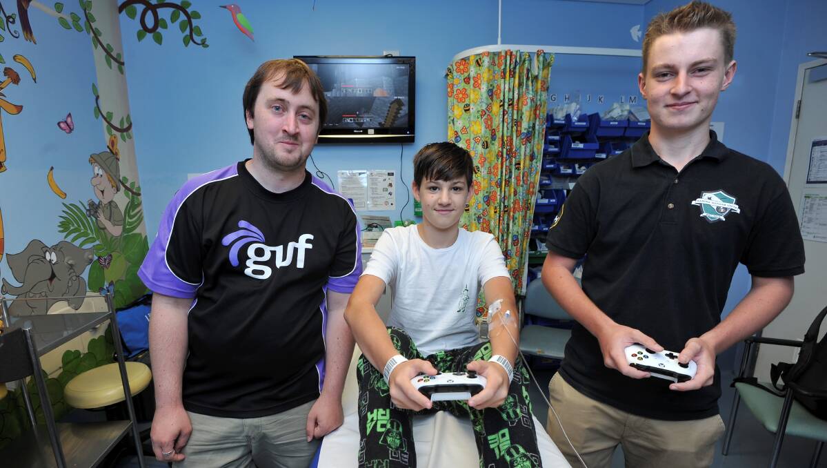 PLAY: GUF's Joshua Sedwick and Gaming Nations Unite's Nick O'Meara challenge 13-year-old patient Kye Tonkin in Minecraft. Picture: Lachlan Bence