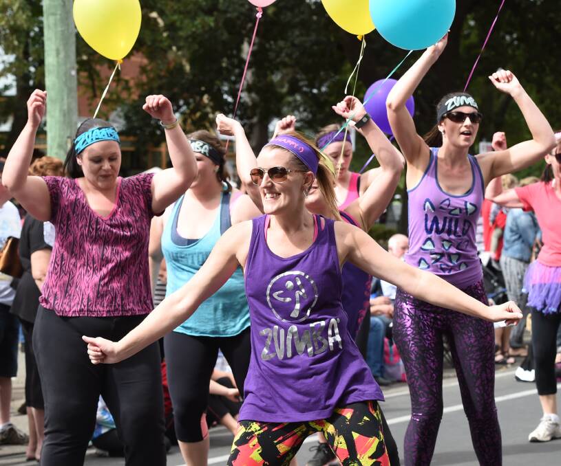 BELOW: Salsa-inspired craze Zumba adds a loud element to the Begonia Festival parade, led by Erin Harris.