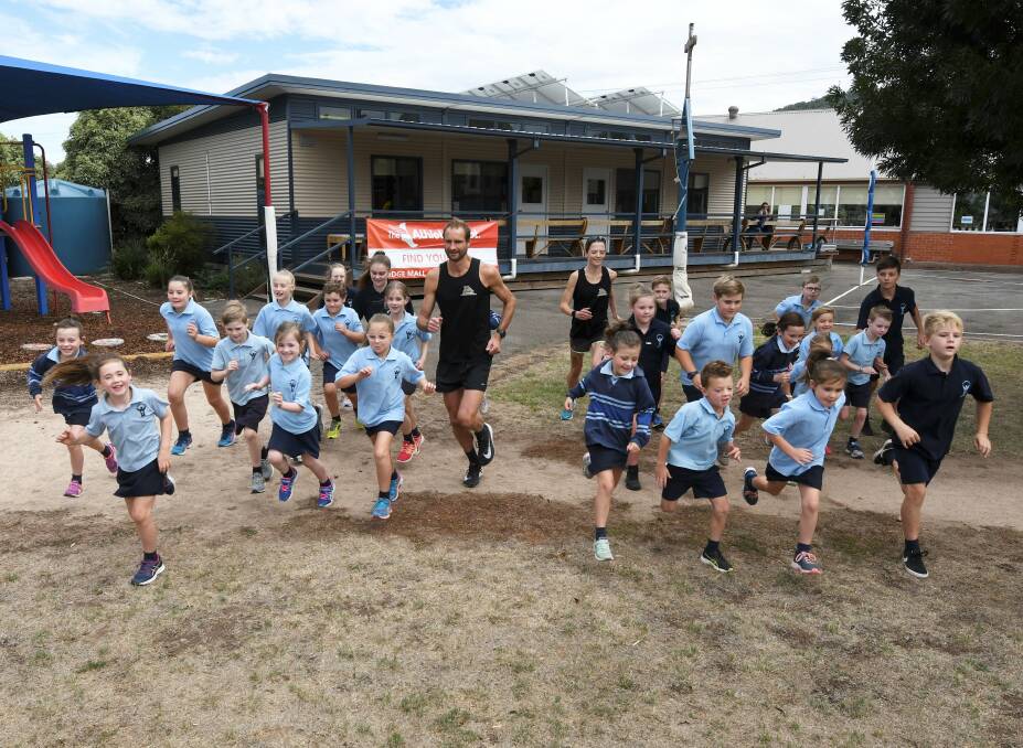 PREPARATION: St Brendan's pupils take a run with reigning men's and women's winners Nic van Raaphorst and Tash Fraser on Friday. Picture: Lachlan Bence