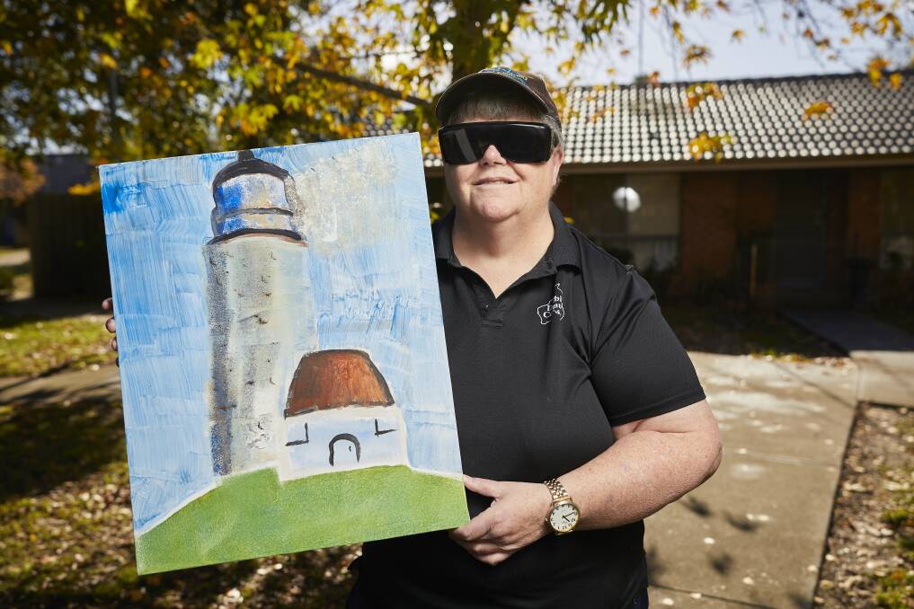 PROUD: Carol O'Connor, who is deaf-blind, says the challenge in painting keeps her mind active but she also finds it relaxing. Picture: Luka Kauzlaric