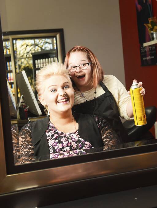 BEAUTY SPOT: Jenna Rathgeber finishes her sister and, new boss, Nikita Morvell's 'do with a little hairspray. Jen's story has attracted global attention. Picture: Luka Kauzlaric
