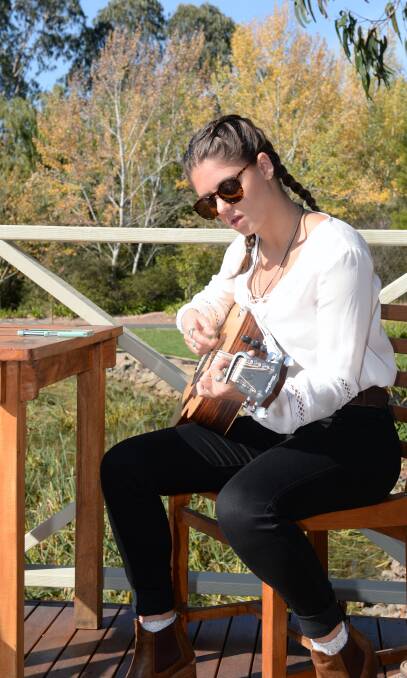 TUNING UP: Songstress Zoe Stevano strums away on the sunny deck before her audition. "Music is the only thing I'm good at right now," Zoe said. Picture: Kate Healy