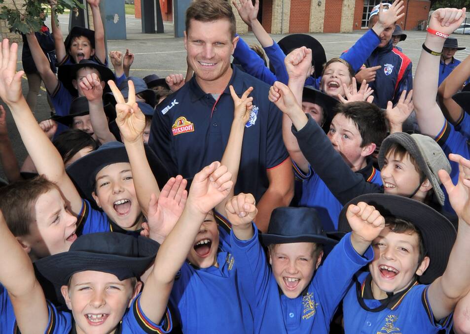 RECEPTION: Bulldog Jack Redpath receives a rock-star reception from Pleasant Street Primary School in the club's AFL Community Camp last year.